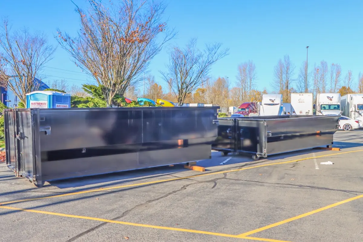 Professional dumpster rental service with roll-off container on residential driveway in Palisades Park